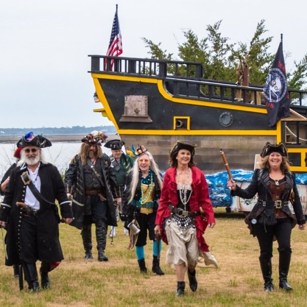 a group of people standing on top of a grass covered field