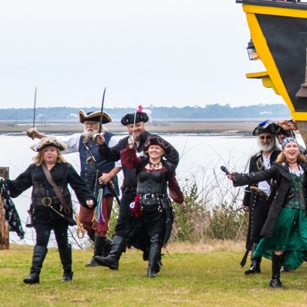 a group of people standing on top of a grass covered field
