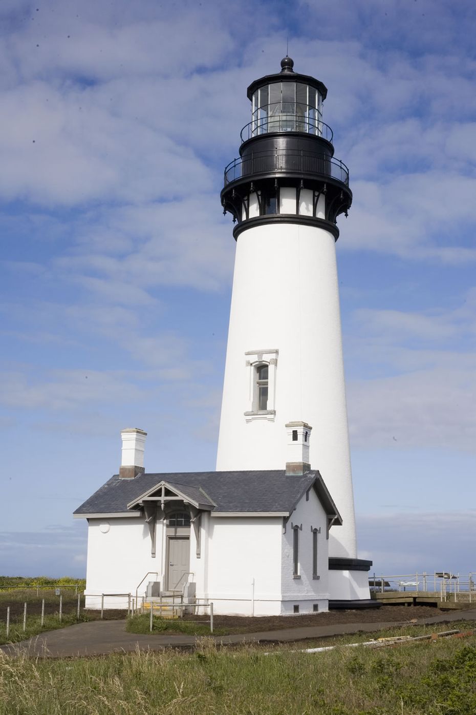 the tower of the building with Yaquina Head Light in the background