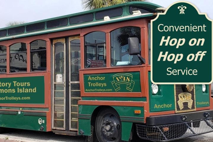 Green tour trolley with 'Convenient Hop on Hop off Service' sign on side.
